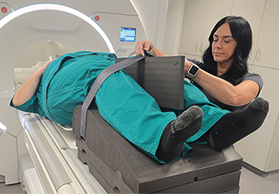 Technologist arranging KyphoWedge comfort pads and securing the leg strap